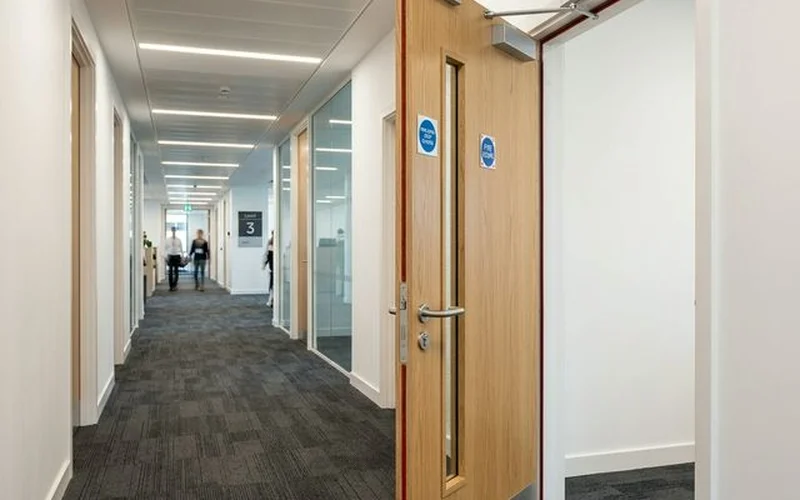 Fire door inspection for commercial offices — UK office building corridor with fire doors